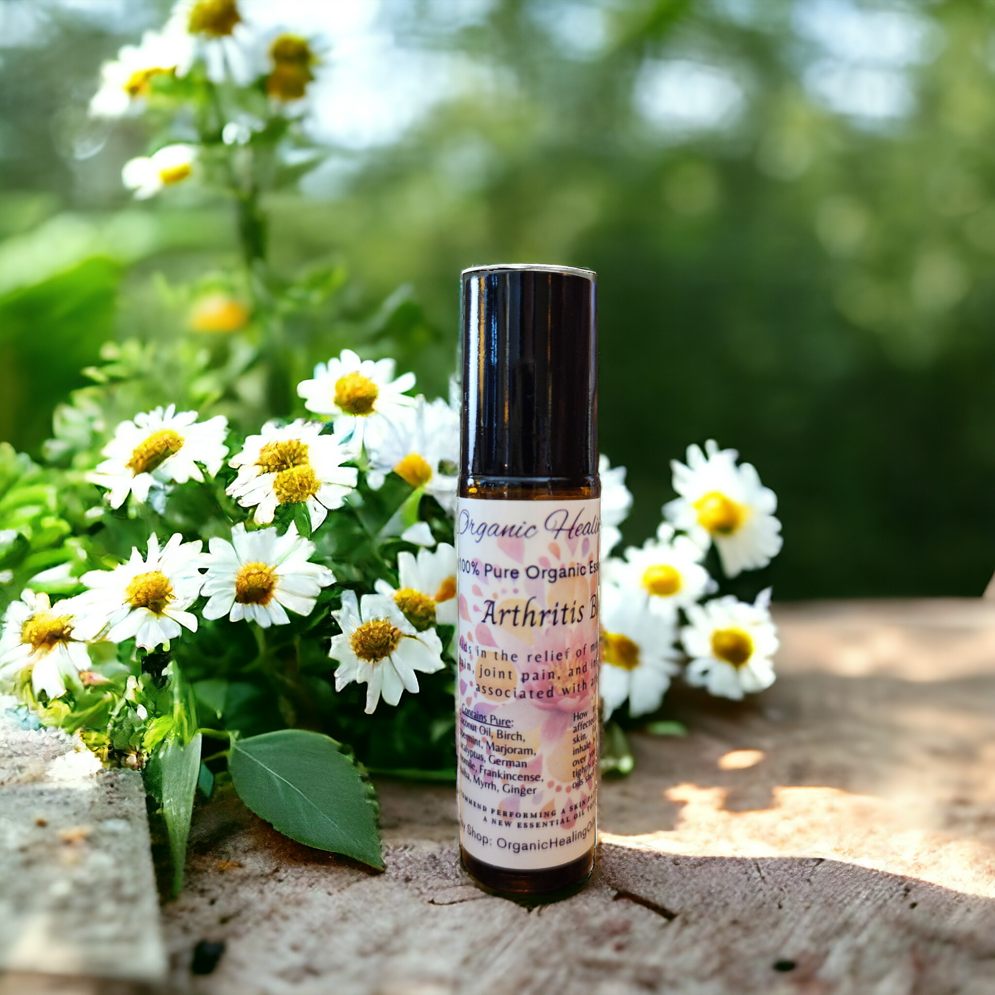 Arthritis Support Essential Oil roller for natural joint and muscle pain relief, shown with chamomile and herbal plants