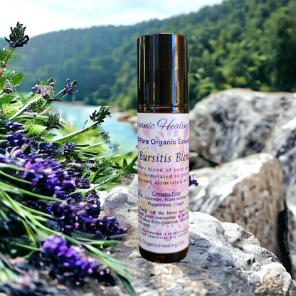 Organic Healing Oils Bursitis Soothing Blend roller displayed on rocks by a tranquil lake, emphasizing its natural formulation for joint care.