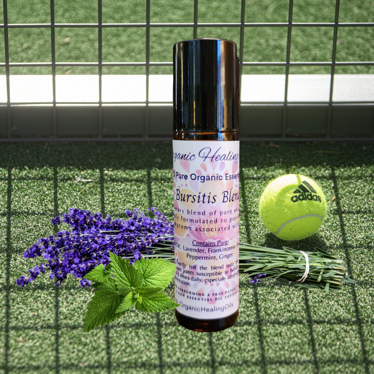 Organic Healing Oils Bursitis Soothing Blend roller, presented on a tennis court with lavender and mint leaves, suggesting active lifestyle support.