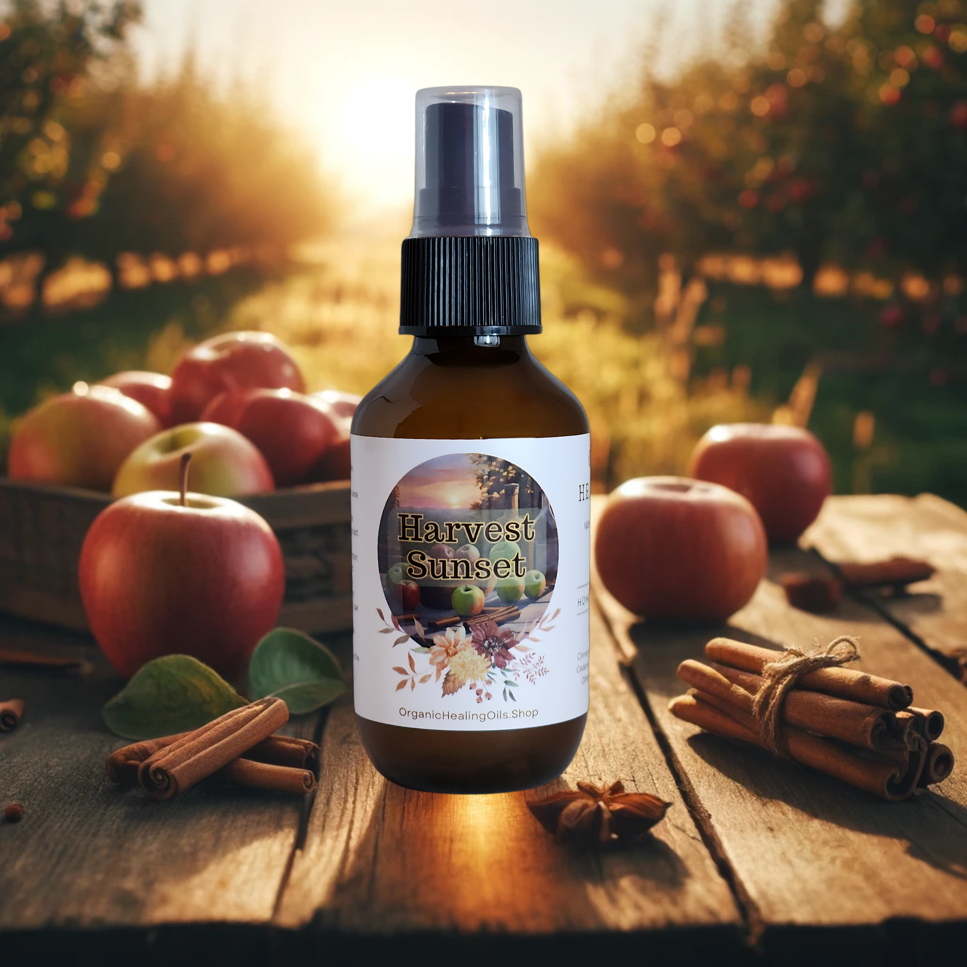 Harvest Sunset spray bottle by Organic Healing Oils, on a rustic table surrounded by apples and cinnamon sticks with a sunset in the background. The scene captures the essence of the harvest season, evoking a warm and inviting autumn atmosphere.