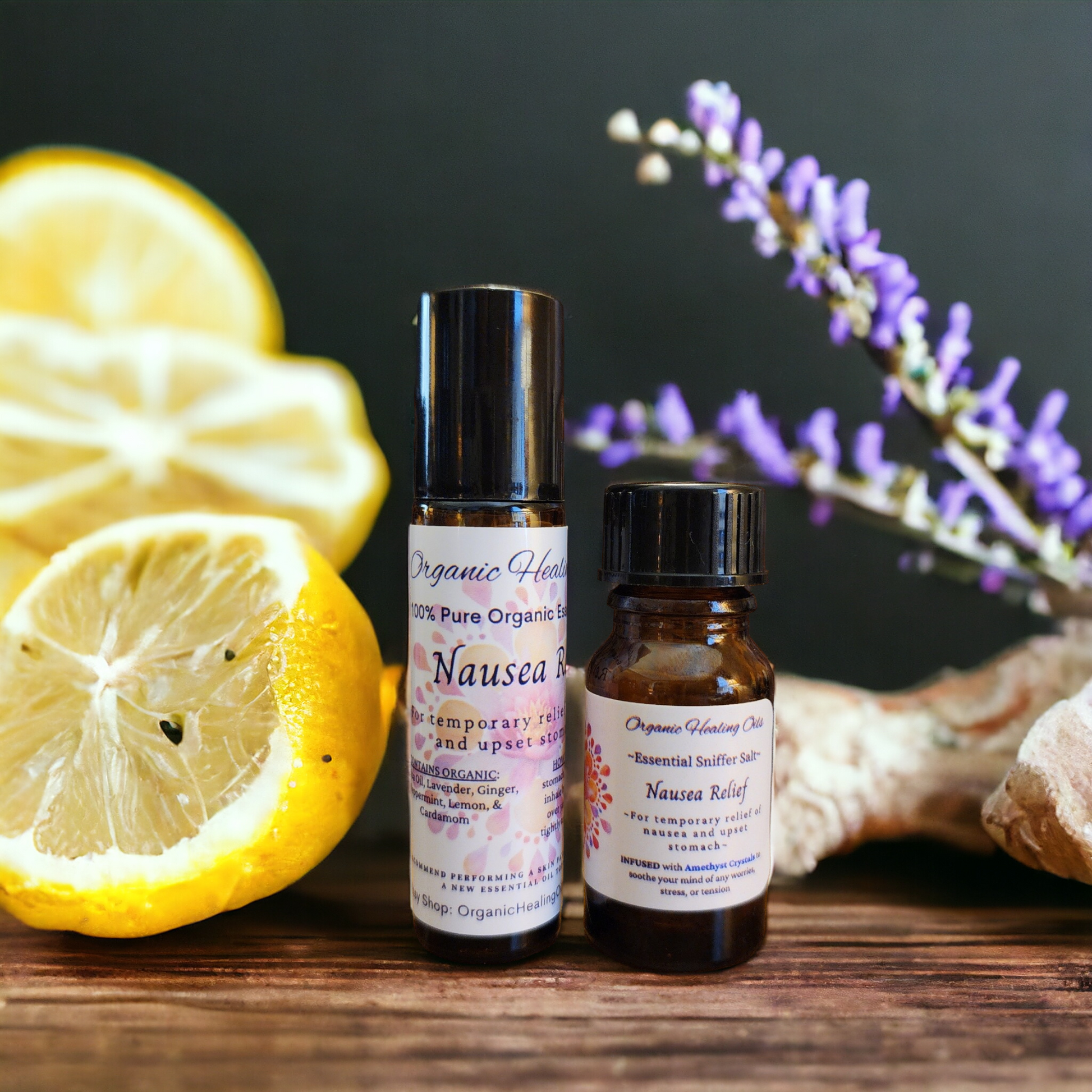 A product display of Organic Healing Oils' Nausea Calming Oil Roller and Sniffer Salt, with natural elements in the background, including sliced lemons and lavender sprigs, indicating the organic ingredients used.