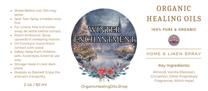 Label for Winter Enchantment Home & Linen Spray by Organic Healing Oils. The label features a snowy winter village scene with a church and Christmas decorations. Instructions for use are on the left. The product is described as 100% pure and organic, highlighting key ingredients like almond, vanilla oleoresin, cinnamon, other proprietary fragrances, and witch hazel.